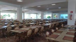 una sala da pranzo vuota con tavoli e sedie di Apartamento Lacqua diRoma 2 a Caldas Novas