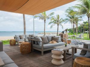 a patio with a couch and chairs on the beach at Sadara Resort in Nusa Dua