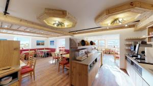 cocina grande y comedor con mesas y sillas en Familienhotel Central, en Sankt Johann in Tirol