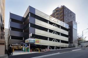 a large black building with a parking lot at Center Hotel Narita1 in Narita