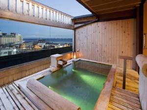 Yunokawa Kanko Hotel Shoen في هاكوداته: حوض استحمام ساخن على شرفة المبنى