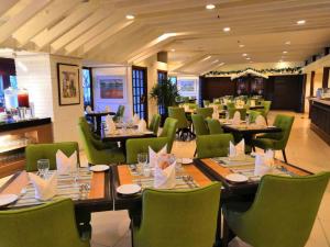 فندق إمبيانا إبوه في ايبوه: غرفة طعام مع طاولات وكراسي خضراء