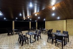 a dining room with tables and chairs and lights at Camp Bagheera in Rishīkesh