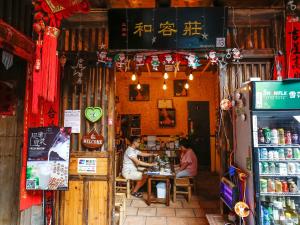 duas pessoas sentadas numa mesa num restaurante em Tulou Herongzhuang Inn em Nanjing