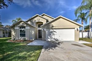 a house with a garage and palm trees at Mickeys Landing - Luxurious 4BR with 2 Master Suites, Privacy Fenced Pool & Hot Tub BBQ Game RM 2 miles to Disney! in Orlando