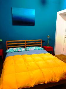 1 dormitorio con cama amarilla y pared azul en 62 B&B en Vicenza