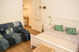 a small bedroom with a bed and a couch at Vincenti Strait Street Suite in Valletta