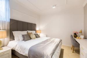um quarto com uma grande cama branca e uma cabeceira preta em MM House em Zagreb