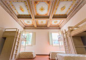 a room with several bunk beds and a coffered ceiling at Student's Hostel Estense in Ferrara +48 photos