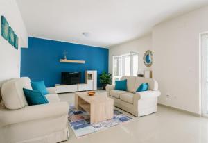 a living room with blue walls and white furniture at Villa Sladovic in Herceg-Novi