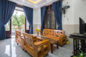 - une salle à manger avec une table et des chaises en bois dans l'établissement New Destination Hoi An, à Hội An