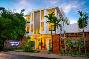 a building with palm trees in front of it at Popular Hotel & Spa in Siem Reap