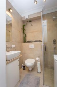 a bathroom with a toilet and a sink and a shower at CR Apartament Ścisłe Centrum Aleja Bluesa in Białystok