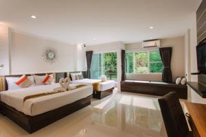 a bedroom with two beds and a large window at Ingnam Pool Villa in Krabi town