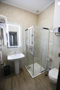 a bathroom with a shower and a sink and a toilet at Hotel Donald in Odesa