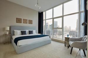 a bedroom with a bed and a large window at Fantastay - Clara Dubai Marina in Dubai