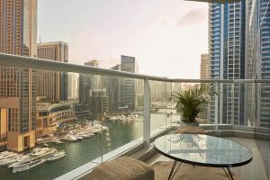 a balcony with a view of a river and boats at Fantastay - Clara Dubai Marina in Dubai