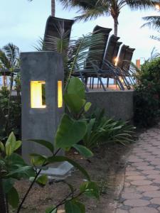 a house with a light on it next to chairs at Noble House Beach Resort in Ko Lanta