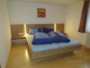 a bed in a room with blue pillows on it at Ferienwohnung Birgit in Sankt Gallenkirch