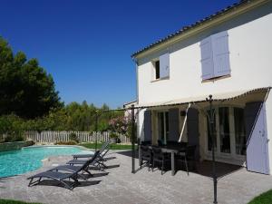 a house with chairs and a swimming pool at Golf de Pont Royal Villa du Lac climatisée 3 chambres Piscine chauffée Parking et Garage in Mallemort