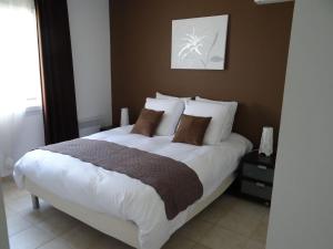 a bedroom with a large bed with white sheets and pillows at Golf de Pont Royal Villa du Lac climatisée 3 chambres Piscine chauffée Parking et Garage in Mallemort +12 photos