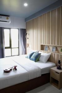 1 dormitorio con 1 cama blanca grande y ventana en Bangkok Boutique Resort Rangsit, en Pathum Thani