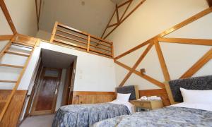 een slaapkamer met 2 bedden en een stapelladder bij Okinoshima Resort Island Park Hotel in Tsudo