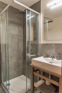 a bathroom with a glass shower and a sink at Chesa La Giunfra - Celerina in Celerina