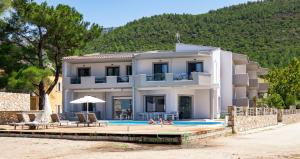 a large white house with a swimming pool at Rachoni Imperial in Skala Rachoniou