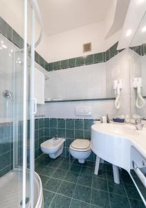La salle de bains est pourvue de 2 lavabos, de toilettes et d'une douche. dans l'établissement Hotel Palm Beach, à Lido di Jesolo