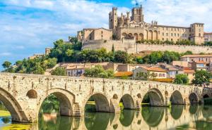 un puente sobre un río con un castillo en el fondo en Béziers Apart Art Déco, en Béziers