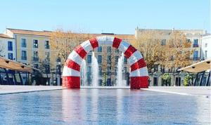 une arche rouge et blanche devant une fontaine dans l'établissement Béziers Apart Art Déco, à Béziers