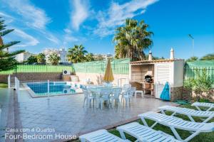 a patio with a table and chairs next to a pool at Akivillas Albufeira Star in Albufeira
