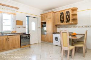 a kitchen with wooden cabinets and a table and chairs at Akivillas Albufeira Star in Albufeira