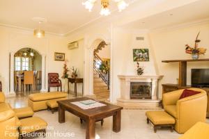 a living room with yellow furniture and a fireplace at Akivillas Albufeira Star in Albufeira