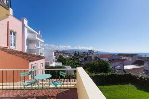 a balcony with chairs and a view of the city at A Bica Hostel in Ponta Delgada