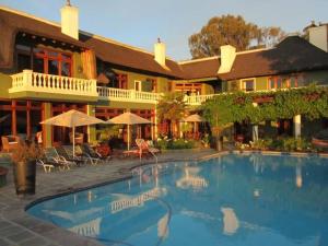 a swimming pool in front of a hotel at Ridgemor Villa in Somerset West
