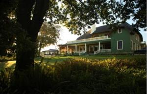 a green house with a tree in front of it at Ridgemor Villa in Somerset West