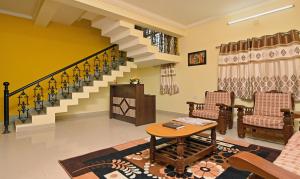 ein Wohnzimmer mit 2 Stühlen und einer Treppe in der Unterkunft Itsy By Treebo - Shivas Kuteera in Bangalore