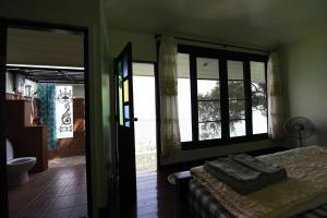 una camera con letto e alcune finestre di Rantee View Bungalow a Phi Phi Don