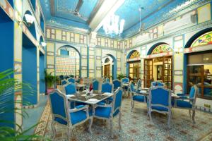 a dining room with blue chairs and a table at Nirbana Palace - A Heritage Hotel and Spa in Jaipur