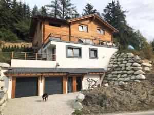 a house with a dog standing in front of it at Chalet Aigle in Crans-Montana