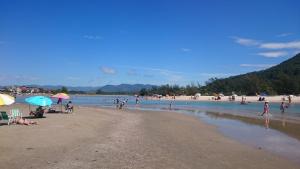 a group of people on a beach in the water at Residencial Sol de Ibiraquera in Barra de Ibiraquera