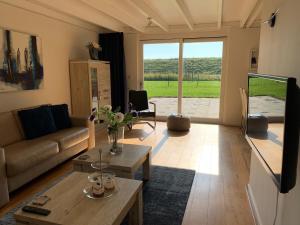 a living room with a couch and a table at Vakantiewoning aan het Veerse meer in Wolphaartsdijk