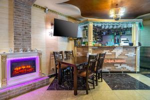 a dining room with a fireplace and a table and chairs at Alpin Hotel in Bukovel