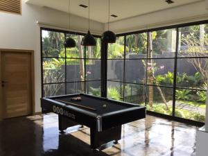 a pool table in a room with large windows at Braya Villa in Ko Yao Yai
