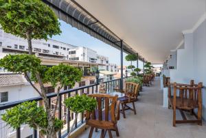 Un balcón con mesas y sillas en un edificio en The Ambiance Hotel en Pattaya centro