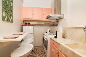 アテネにあるVintage Apartment next to Acropolis Museumの小さなキッチン(ピンクのキャビネット、白い電化製品付)