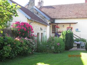 uma casa branca com flores no quintal em Le clos de la perdrix em Bellenot-sous-Pouilly