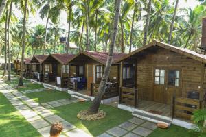 a row of cottages in the middle of palm trees at Agonda Paradise in Agonda